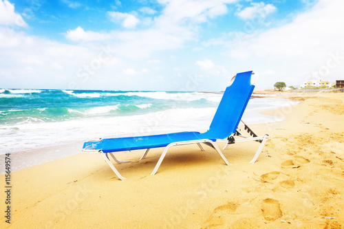 Fototapeta Naklejka Na Ścianę i Meble -  blue chair on Malia beach, Crete Greece, toned