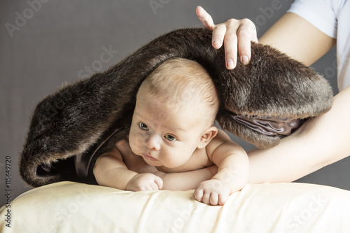 Mom Covering her little caucasian baby with wool blancket photo