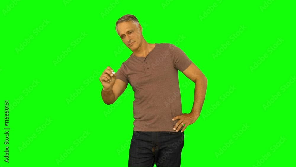 Casual man standing and drawing line on green screen background Casual man standing and drawing line on green screen background