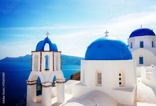 volcano caldera with blue church domes and belfry, Oia Santorini, toned