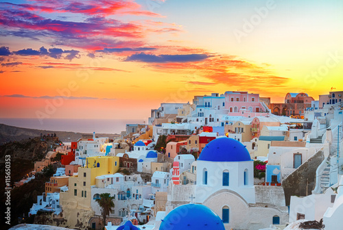 cityscape of Oia, traditional greek village of Santorini, with blue domes of churches at sunset, Greece, toned