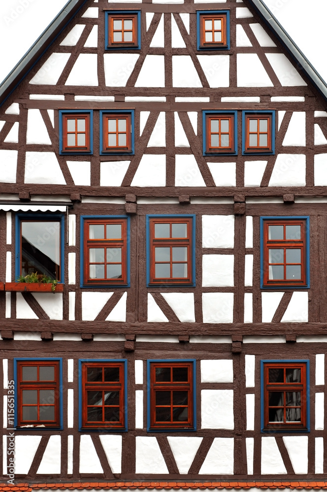 Front view of a typical half-timbered house with brown frame, white filling and brown windows. Front view of a typical half-timbered house with brown frame, white filling and brown windows.