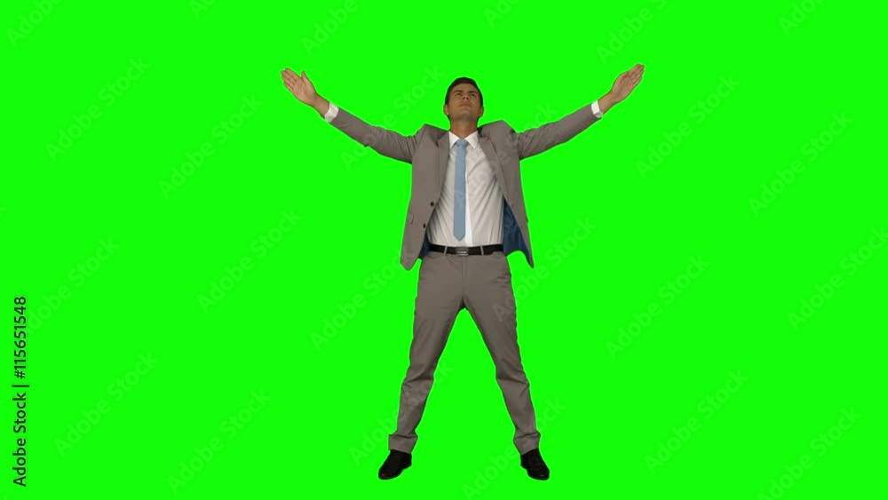 Businessman standing with arms raised on green screen background Businessman standing with arms raised on green screen background