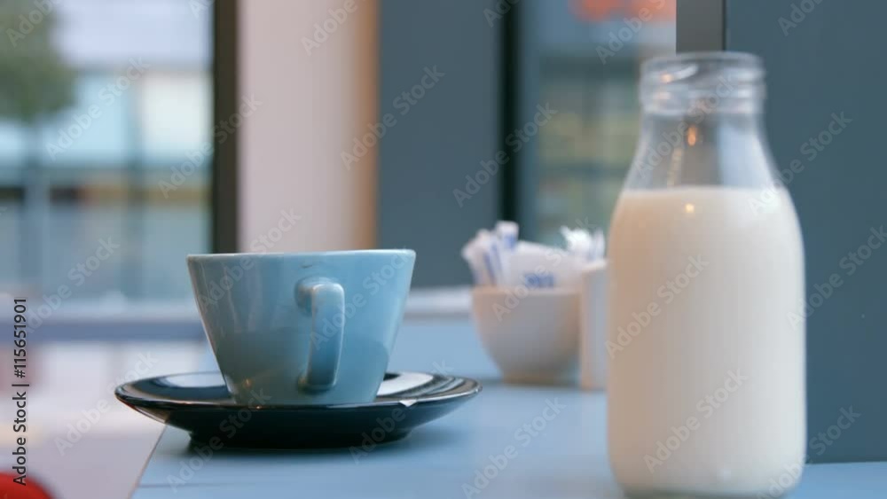 Milk jug and cup on cafe table Milk jug and cup on cafe table