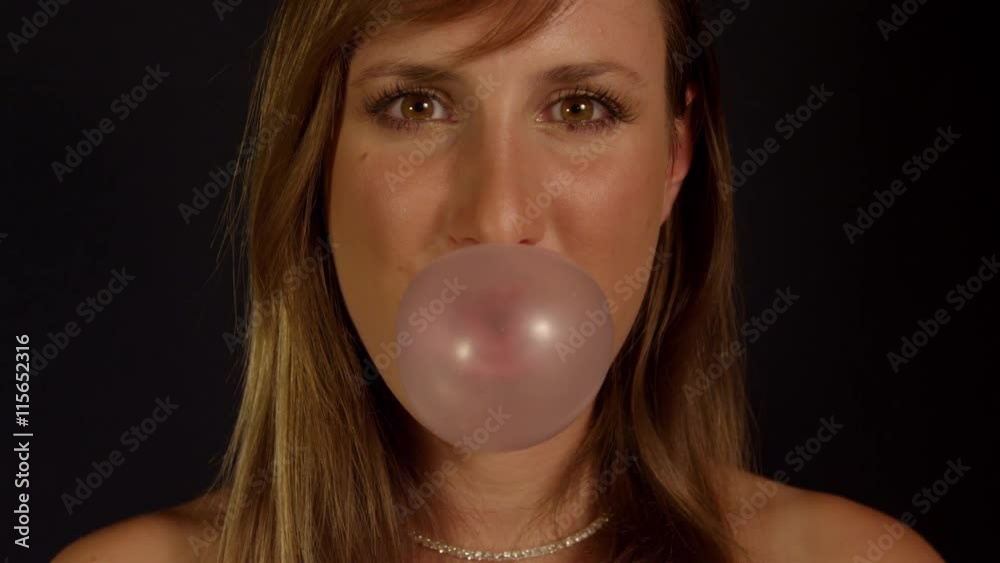 SLOW MOTION: Woman blowing gum bubbles
