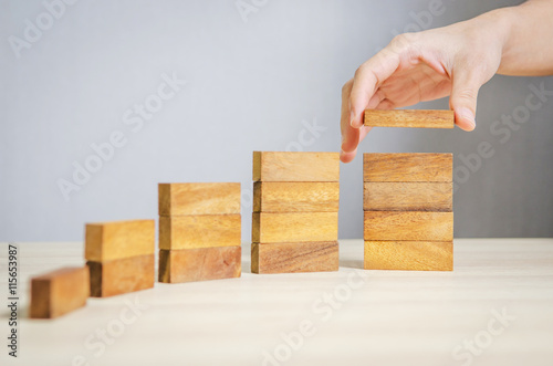 Close up Woman hand arranging wood block stacking as step stair. Business concept growth success process.