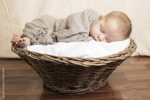 Small Baby sleeping inside wooden basket