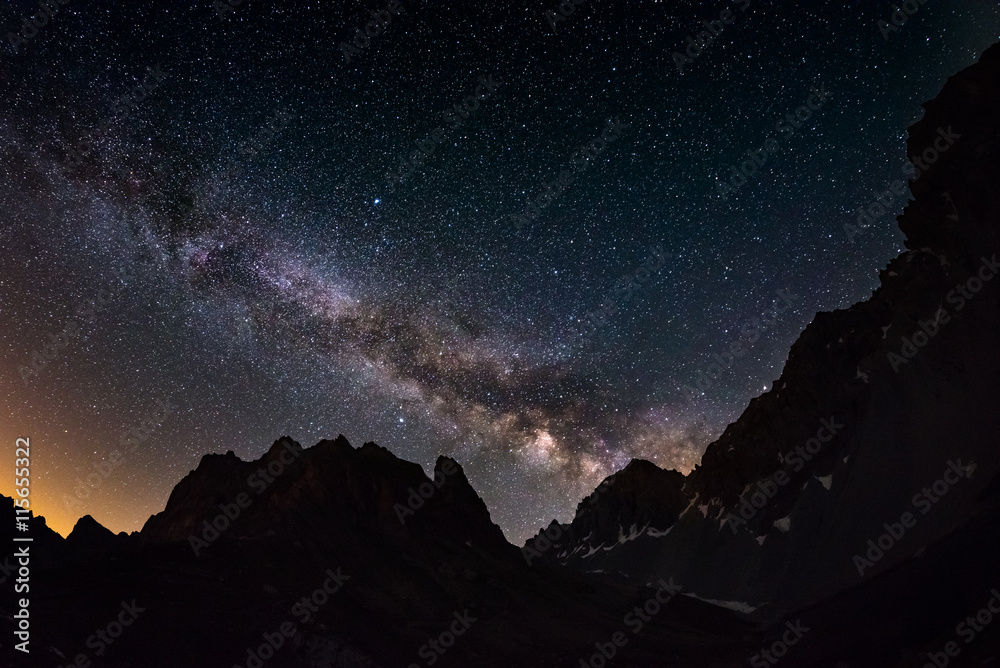 Naklejka premium The outstanding beauty of the Milky Way arc and the starry sky captured at high altitude in summertime on the Italian Alps, Torino Province. Fisheye scenic distortion and 180 degree view.