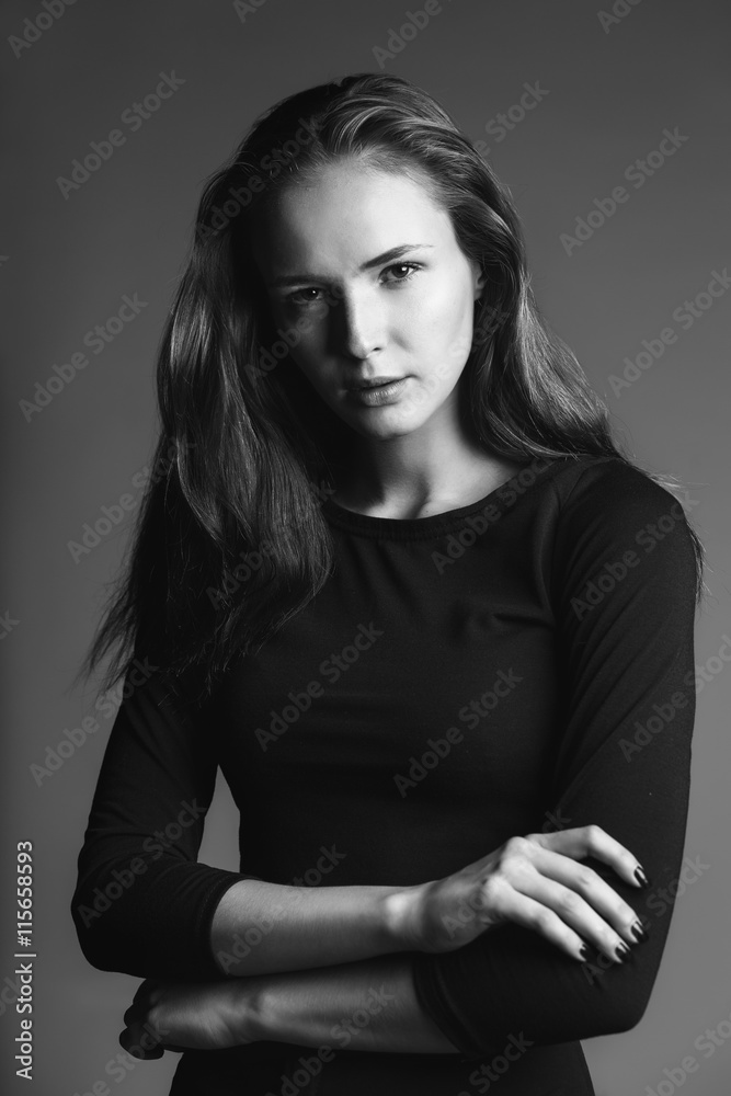 monochrome fashion moody portrait of young woman on gray background