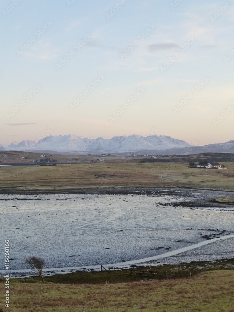 Winter sunset on the Isle of Skye with the Cuillin Hills in the distance and Loch Roag at low tide in the foreground