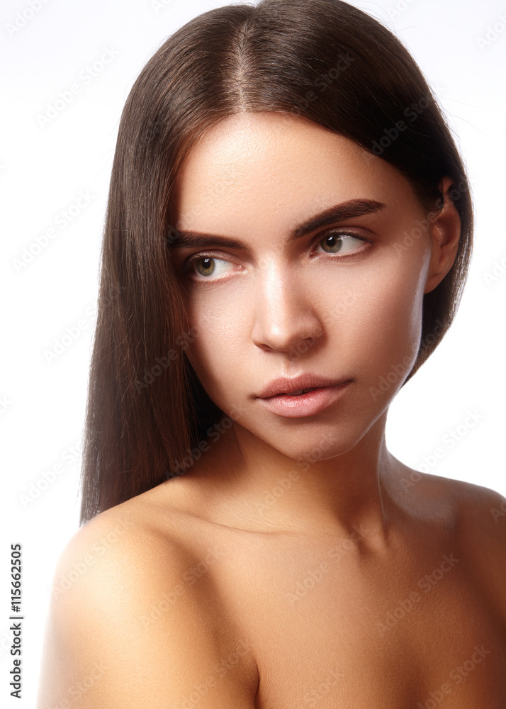 Fototapeta premium Beautiful young woman with clean face, shiny skin, fashion natural make-up, perfection eyebrows. Cute bun hairstyle. Spa portrait, naturel cosmetics, healthy fresh look