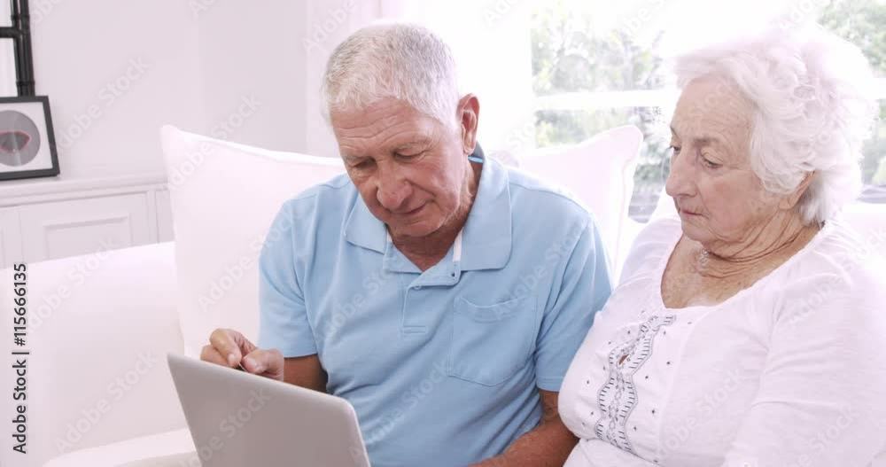 Senior couple using laptop and talking Senior couple using laptop and talking