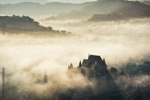 Misty morning over Biertan village, Transylvania, Romania photo