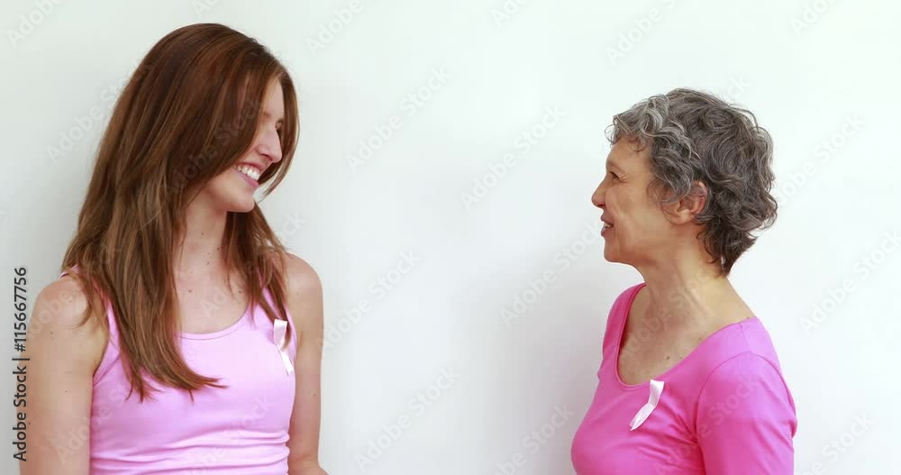 Happy women with pink ribbon on shirts talking Happy women with pink ribbon on shirts talking