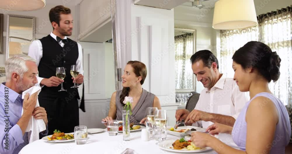Waiter attending to a table of friends Waiter attending to a table of friends
