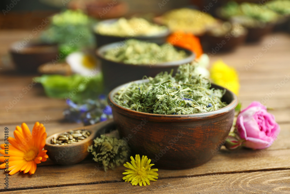 Herb selection and fresh flowers in bowls on wooden background Herb selection and fresh flowers in bowls on wooden background