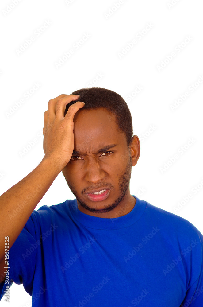 Headshot stressed man wearing strong blue colored t-shirt using hands touching his own head frustrated, white studio background Headshot stressed man wearing strong blue colored t-shirt using hands touching his own head frustrated, white studio background