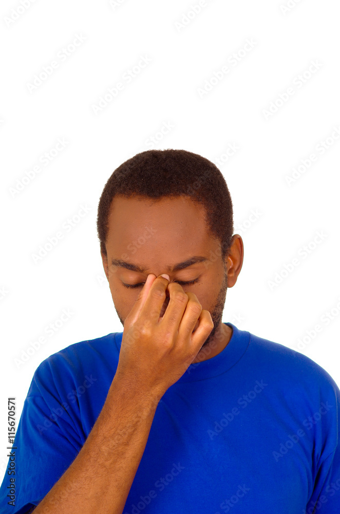 Headshot stressed man wearing strong blue colored t-shirt using hands touching his own head frustrated, white studio background Headshot stressed man wearing strong blue colored t-shirt using hands touching his own head frustrated, white studio background