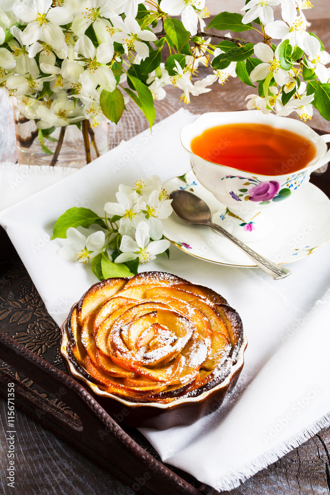 Apple shaped roses pie and cup of tea on the serving tray