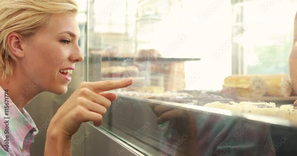 Happy pretty blonde pointing cupcake in high quality 4k format