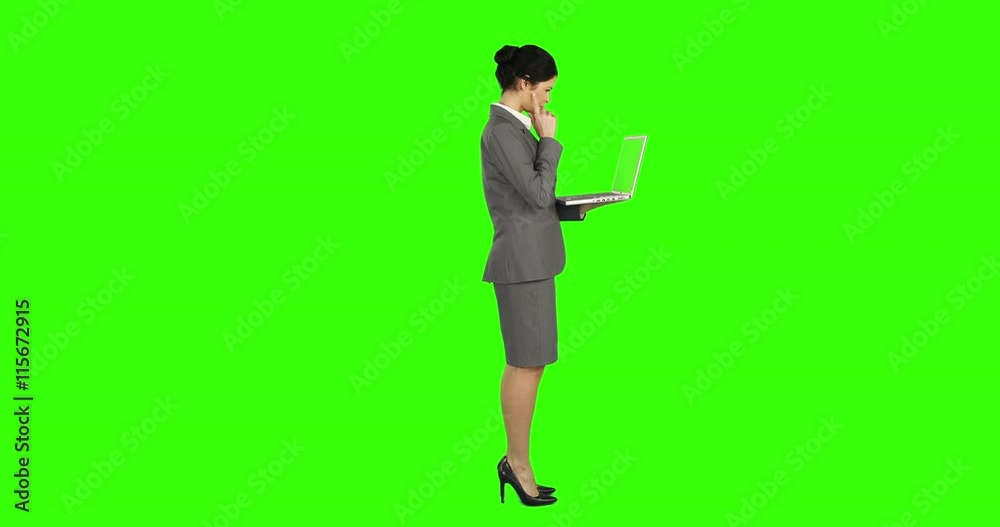 Business woman standing and using a laptop on green screen Business woman standing and using a laptop on green screen