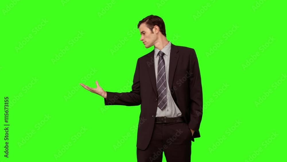 Businessman presenting with his hand on green screen background Businessman presenting with his hand on green screen background