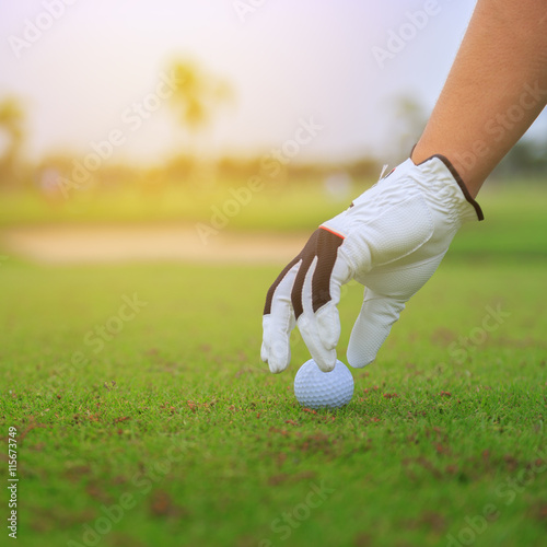 Hand to touch golf ball on the green field in game