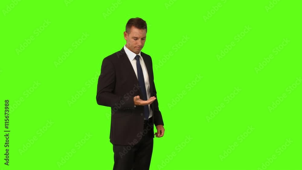 Businessman standing with hand out on green screen background Businessman standing with hand out on green screen background