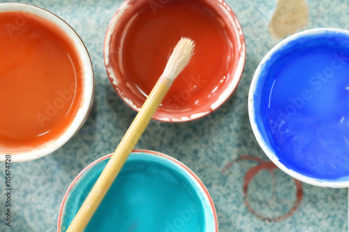 Paint brushes and crafting supplies on the table in a workshop.