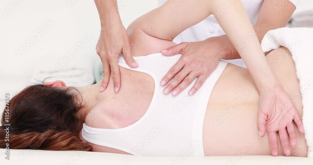 Physiotherapist doing shoulder massage to her patient Physiotherapist doing shoulder massage to her patient