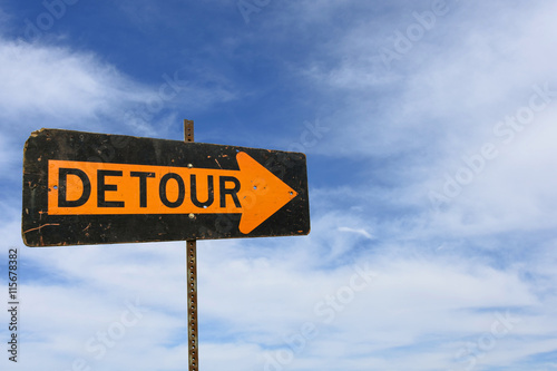 detour sign with wispy clouds in summer sky background photo