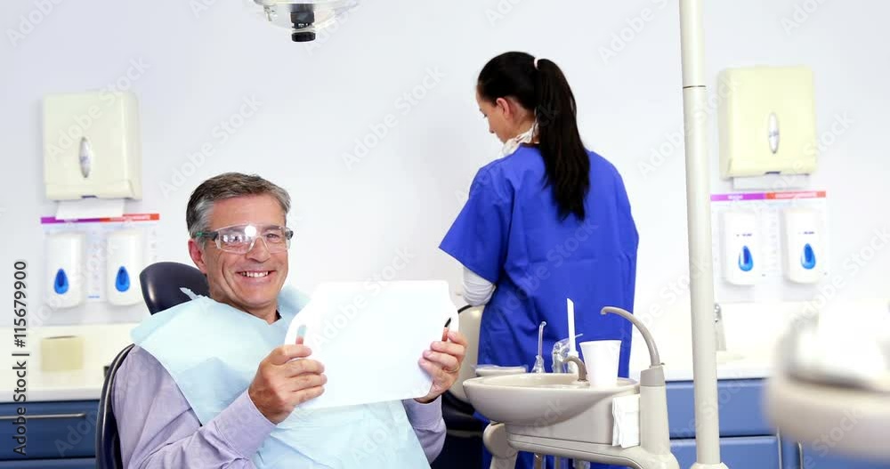 Patient admiring his new smile in the mirror Patient admiring his new smile in the mirror