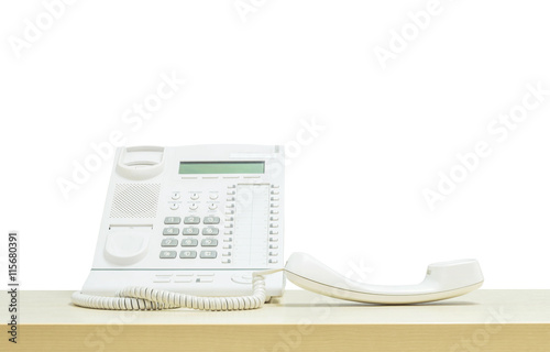 Closeup white phone , office phone on blurred wooden desk in the meeting room under window light isolated on white background