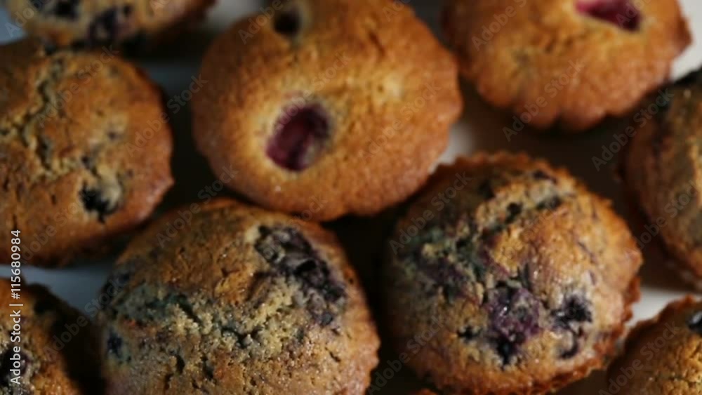 Homemade wholegrain muffins with berries on a white plate. Slow motion Homemade wholegrain muffins with berries on a white plate. Slow motion