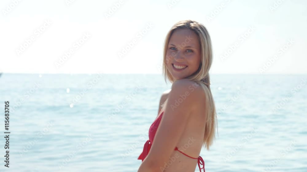 Happy pretty blonde woman looking at camera at the beach Happy pretty blonde woman looking at camera at the beach