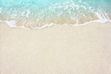 Soft wave of blue ocean on the sandy beach, background.