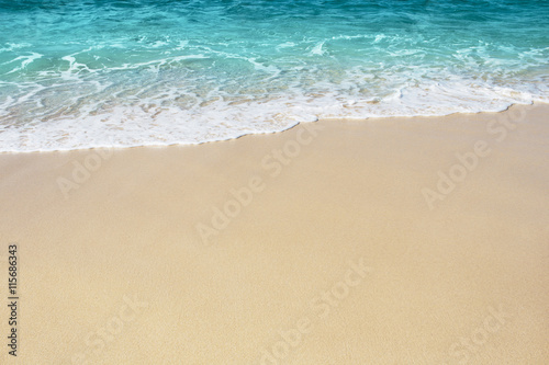 Fototapeta Soft wave of blue ocean on the sandy beach, background.