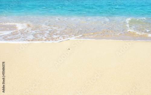 Soft wave of blue ocean on the sandy beach, background.