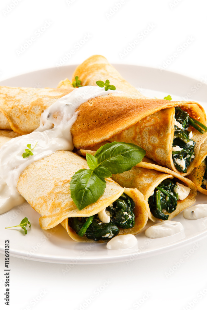 Crepes with spinach and feta cheese on white background Crepes with spinach and feta cheese on white background