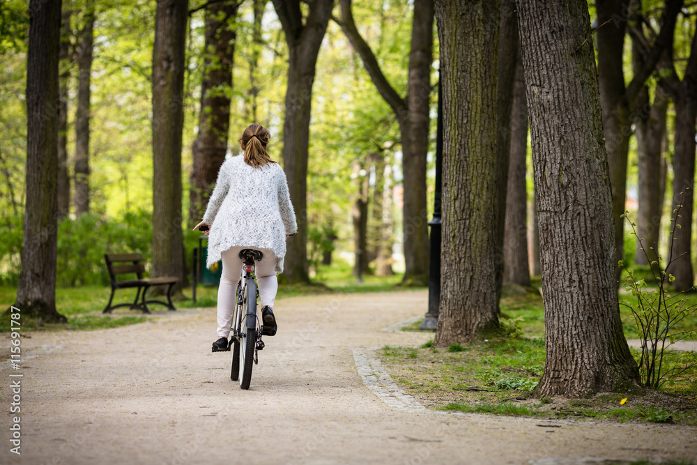 Urban biking - woman riding bike in city park Urban biking - woman riding bike in city park