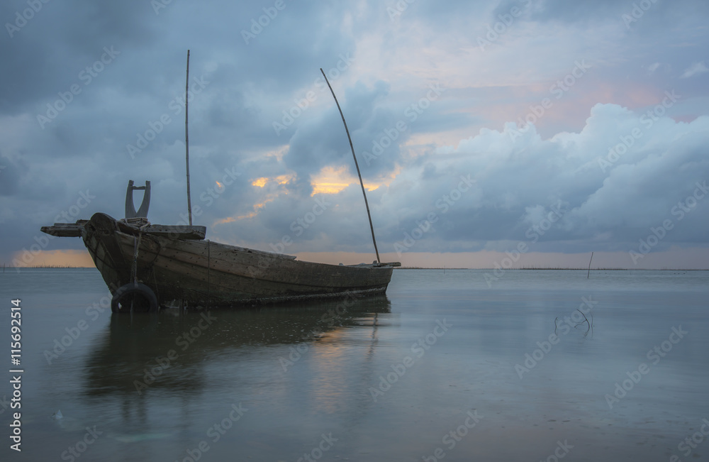 Twilight and sunset at the sea with fishing boat and cargo ship
