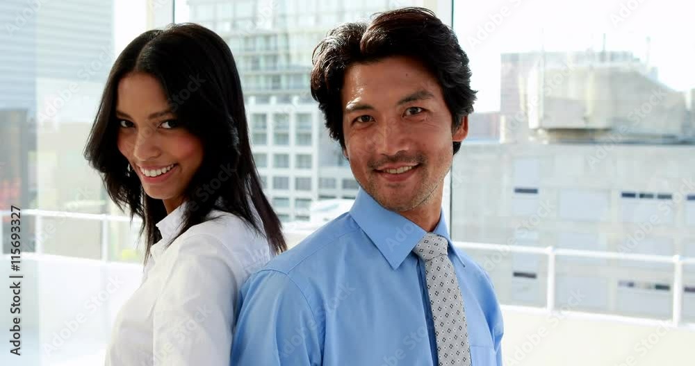 Business partners smiling at camera in the office Business partners smiling at camera in the office
