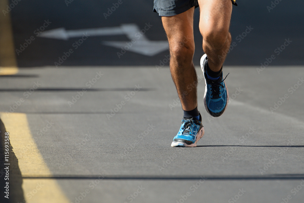 Man running the asphalt road to race in the marathon