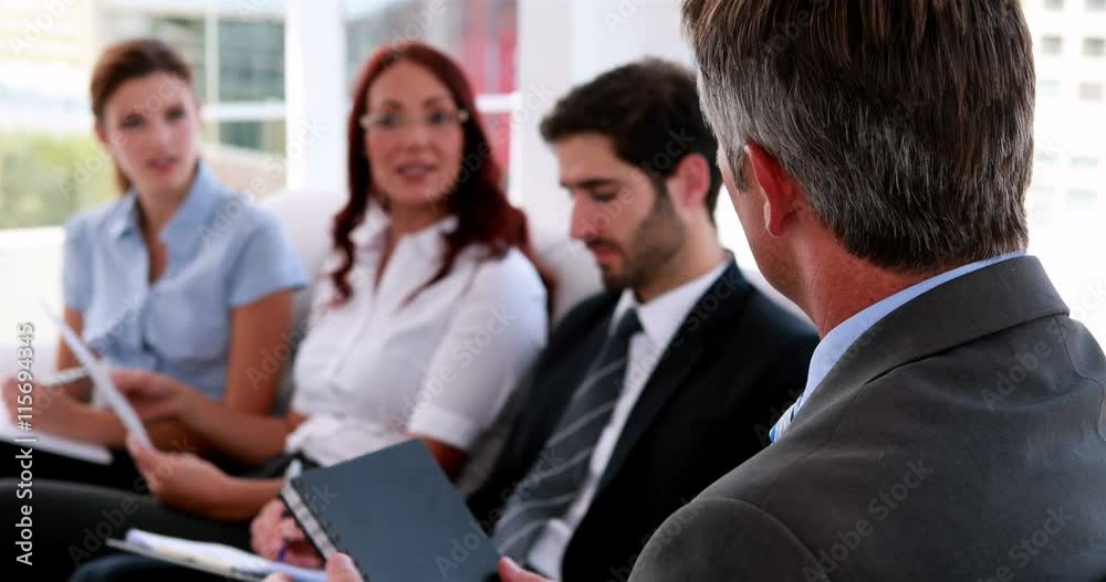 Business team sitting on couch having a meeting in the office Business team sitting on couch having a meeting in the office