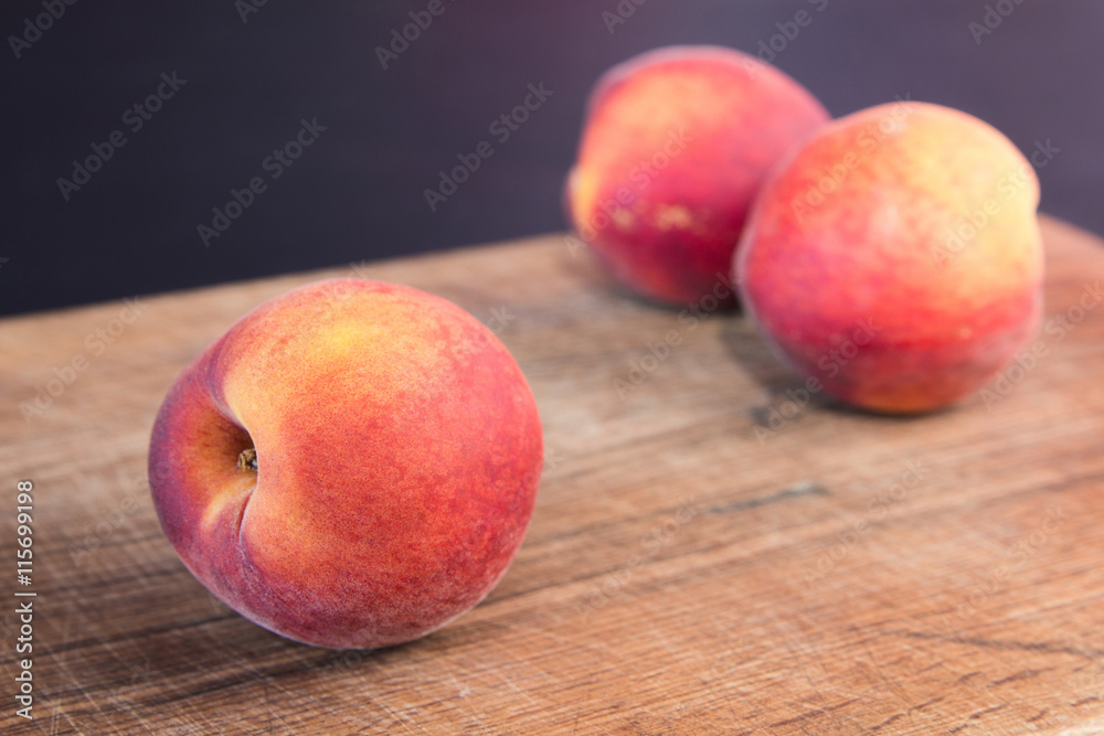 Fresh peaches on a wooden cutting board. Fresh peaches on a wooden cutting board.