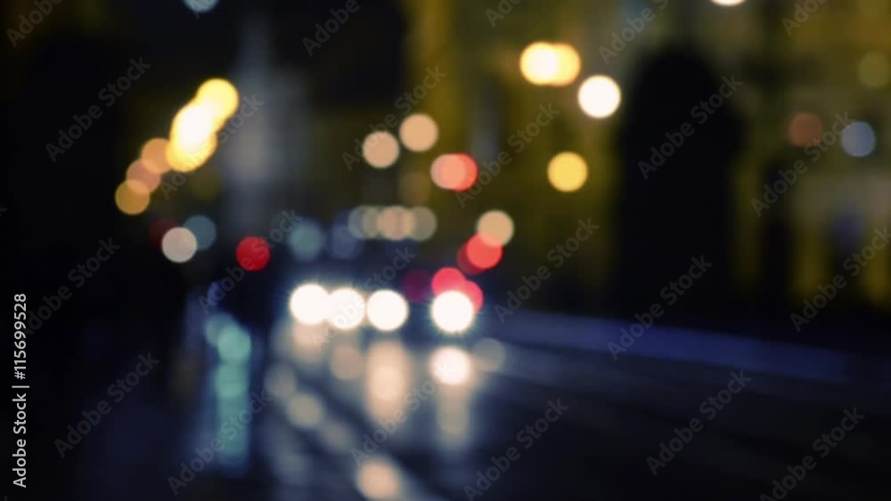 Pedestrians walking in the center of Prague city street at night with light illumination, and traffic of cars and trams. Blurred defocused background. Pedestrians walking in the center of Prague city street at night with light illumination, and traffic of cars and trams. Blurred defocused background.