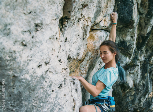 Woman climbing the rock wall