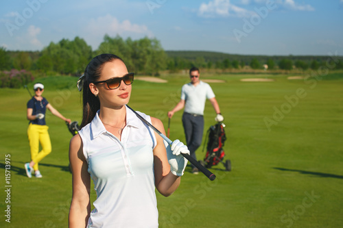 Portrait of young sportive women golfer playing golf with friends at sunny day