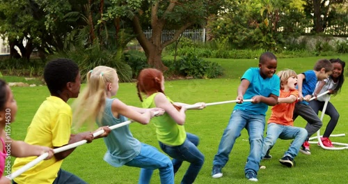 Cute pupils having a tug of war outside the elementary school