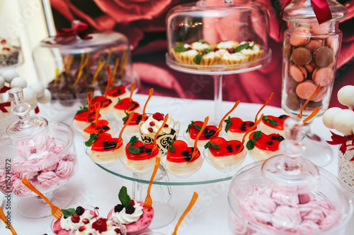A view on a little cheesecakes and macaroons standing in glass v